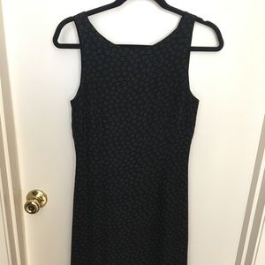 Black sleeveless dress with circle pattern.